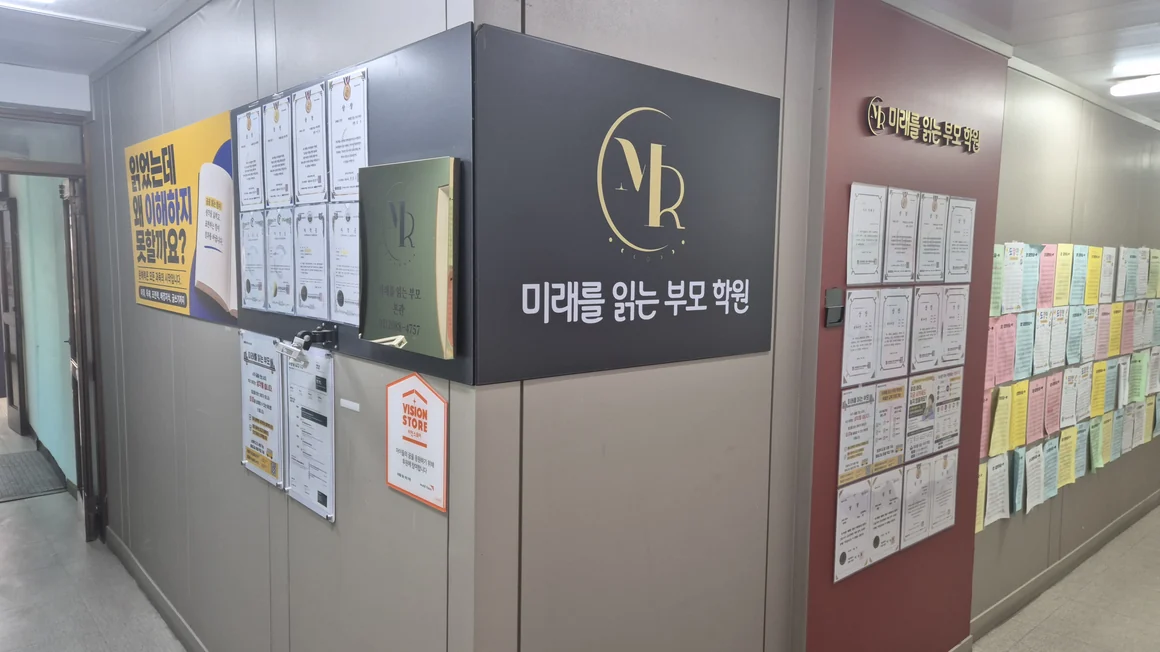 미래를 읽는 부모 학원 상일관 입구 — MR 로고 간판과 벽면 가득한 학생 수상 기록·글쓰기 작품