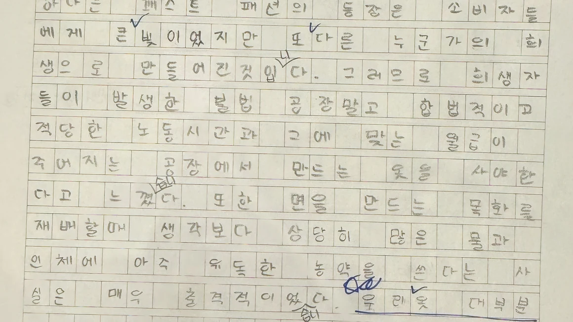학생이 원고지에 쓴 독후감 본문과 선생님이 남긴 파란 펜 첨삭 — 칸을 빼곡히 채운 실제 결과물